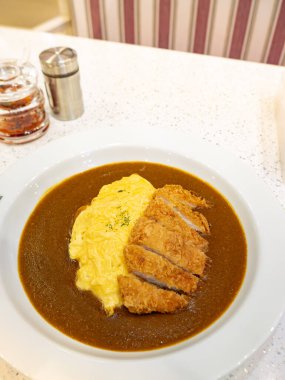 Zengin kahverengi köri soslu kremalı yumurta omletli çıtır Tonkatsu.