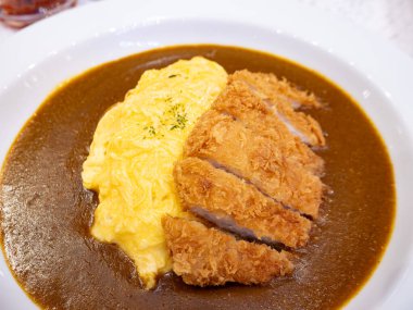 Zengin kahverengi köri soslu kremalı yumurta omletli çıtır Tonkatsu.
