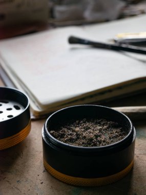 Esrar Öğütücü, Sarma Kağıtlar ve Esrarlı İnce Zemin Marihuanasını Gösteriyor