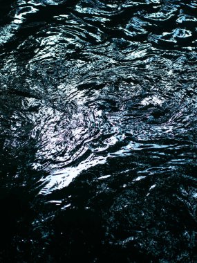 Aydınlık Yansımalar ve Dalgalanmalarla Soyut Karanlık Su Yüzeyi - Gizemli Sıvı Doku Arkaplanı