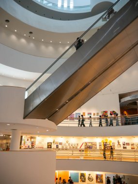 Ziyaretçiler, Bangkok Sanat ve Kültür Merkezi (BACC) bünyesindeki eğri kaldırımlar boyunca çağdaş sanat sergilerini görüyorlar. Toplantı yeri Bangkok, Tayland 'da büyük bir yaratıcı ve kültürel merkez olarak hizmet vermektedir..