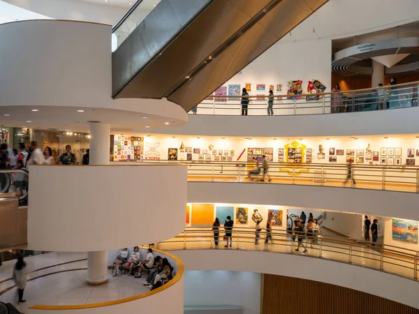 Ziyaretçiler, Bangkok Sanat ve Kültür Merkezi (BACC) bünyesindeki eğri kaldırımlar boyunca çağdaş sanat sergilerini görüyorlar. Toplantı yeri Bangkok, Tayland 'da büyük bir yaratıcı ve kültürel merkez olarak hizmet vermektedir..