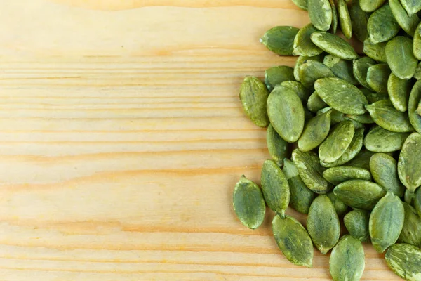 Tahtada tuzsuz yeşil kabak tohumu.