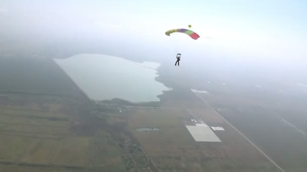 Fallskärmshoppare ned på fallskärm — Stockvideo