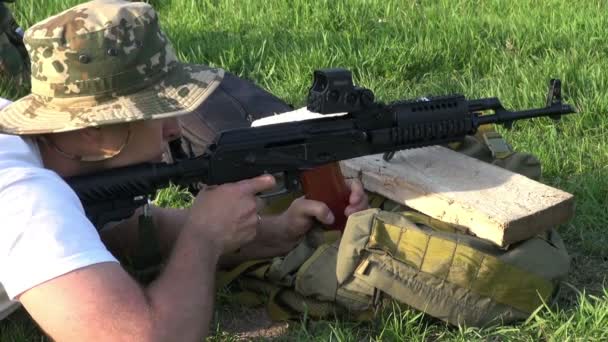 Mannen i kamouflage bränder med gevär — Stockvideo