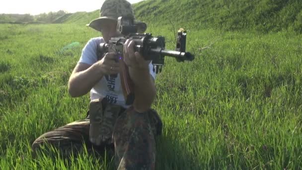 Hombre en fuego de camuflaje con rifle — Vídeo de stock