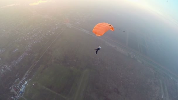 Paracaidista en el cielo sobre la ciudad — Vídeo de stock