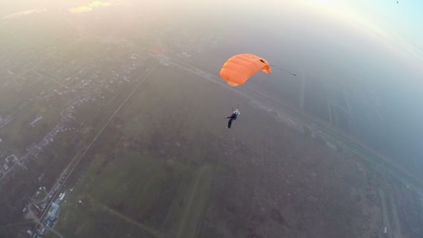 Ejtőernyős az égen a város felett — Stock videók