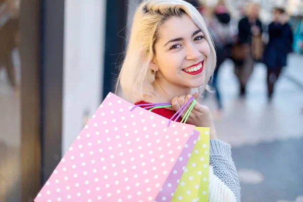 一个带着购物袋的年轻快乐微笑的女人的画像 — 图库照片