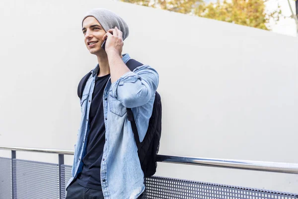 Stedelijke Stijlvolle Man Staat Aan Muur Met Behulp Van Mobiele — Stockfoto