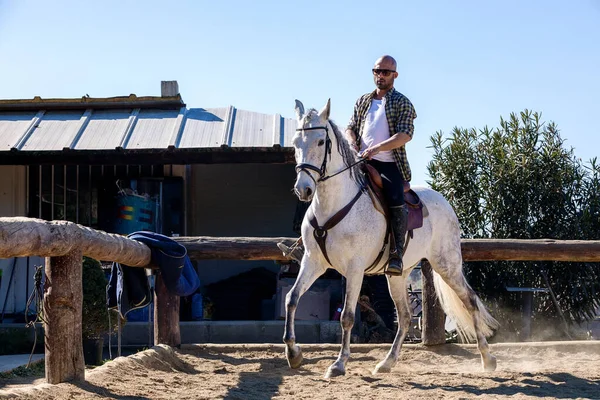 Junger Mann Lässigem Outfit Reitet Weißes Pferd Auf Sandigem Boden — Stockfoto