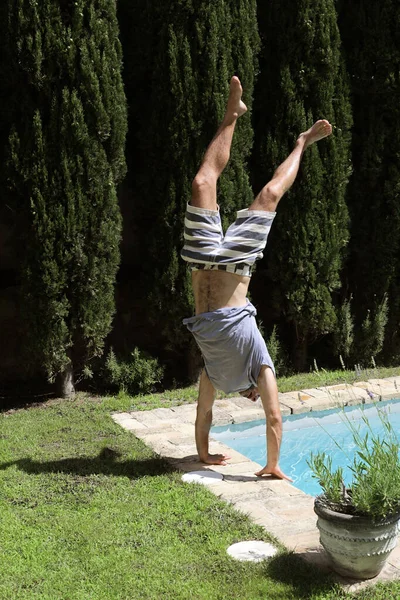 Hombre Usando Camiseta Traje Baño Haciendo Soporte Mano Piscina —  Fotos de Stock