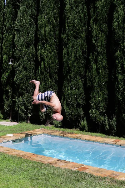 一个男人正在跳进游泳池里打滚 往下跳 跳进水里休息 在海边度假 美丽的风景 — 图库照片