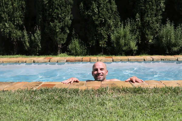 在游泳池边休息的英俊男人的画像暑假的概念 — 图库照片