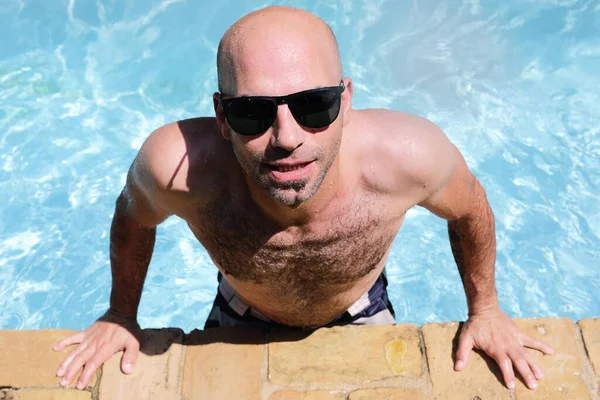 선글라스를 수영장 가장자리에 잘생긴 남자의 — 스톡 사진