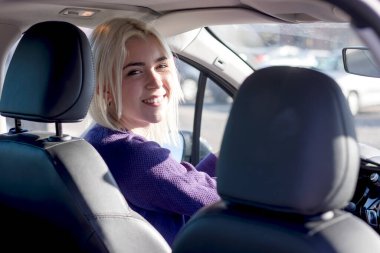 Gün batımında genç, gülümseyen kadın direksiyon arabası