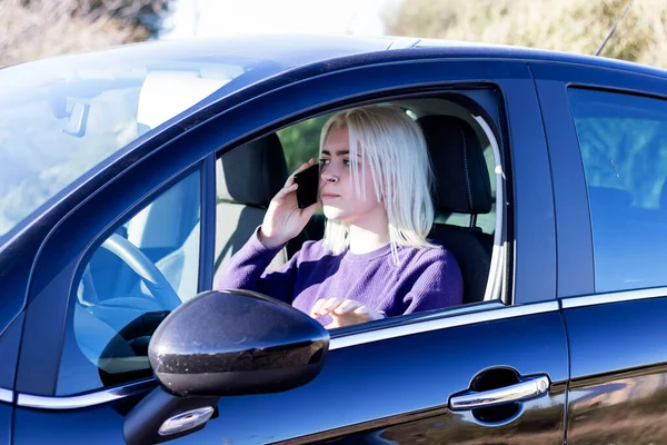 Angry young woman driver talking by phone