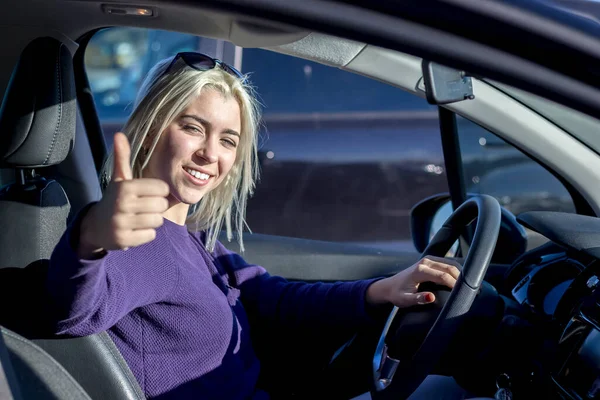 Arabadaki mutlu kadın başparmağını kaldırıyor.