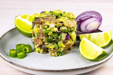 Avokado, limon, acı biber, kırmızı soğan, kişniş ve susam tohumlu deniz mahsullü ton balığı ceviche salatası beyaz ahşap arka planda. Kapatın. Seçici odaklanma. Boşluğu kopyala