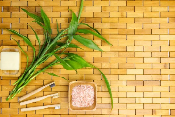 Spa, zen, massage concept. Bath salt, bamboo leaves, soap dish, toothbrush. Top view. Flat lay.