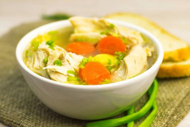 Tavuk çorbası çorbası çorbası çorbası ve sebzeler eski bir ahşap kesim tahtasının üzerinde beyaz kasede. Kapatın. Seçici odaklanma. Boşluğu kopyala