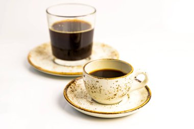 Sabah kahve konsepti. Bir sürü fincan çay tabağı ve beyaz arka planda cam tabaklar. Seçici yumuşak odaklanma. Metin kopyalama alanı