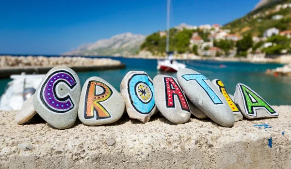 Croazia nome dipinto sulle pietre, barca nel porto turistico sullo sfondo — Foto Stock