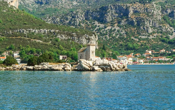 Small white church on the island, Mediterranean sea and high mountains in the background — Stock Photo, Image