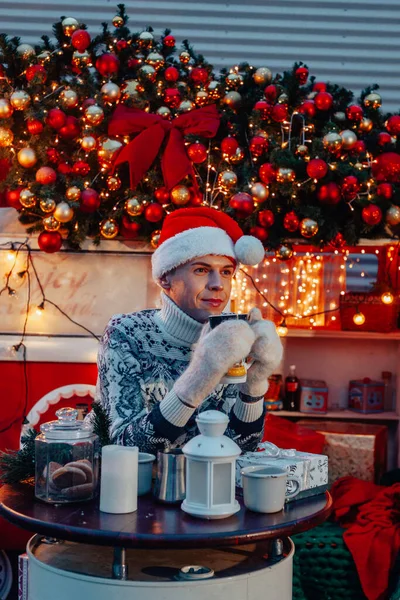 サンタ クラスの少年クリスマスバスの近くでコーヒーを飲む — ストック写真