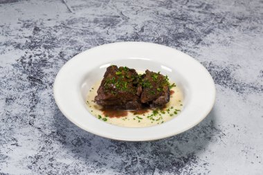 Lezzetli kırmızı şarap patates püresinin üzerinde pişmiş pirzola.