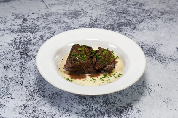 Lezzetli kırmızı şarap patates püresinin üzerinde pişmiş pirzola.