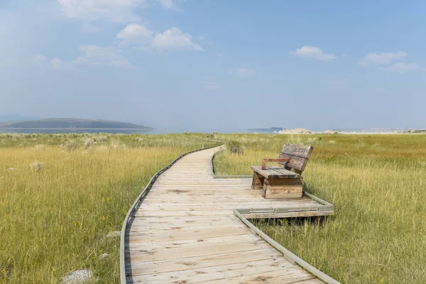 Mono Gölü, Kaliforniya 'da, tahta kaldırımda tek başına bir bank oturuyor.