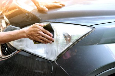 Benzin istasyonunda güç tamponu makinesiyle arabada büyük bir far temizliği, önce ve sonra güç tampon makinesi kullanarak arabanın farlarını temizleyen bir tamirci ile araba konsepti. 