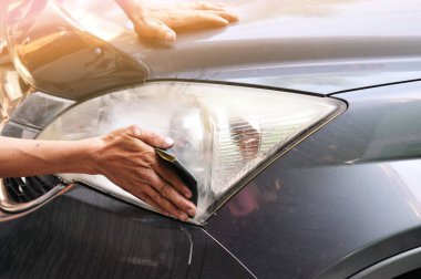 Benzin istasyonunda güç tamponu makinesiyle arabada büyük bir far temizliği, önce ve sonra güç tampon makinesi kullanarak arabanın farlarını temizleyen bir tamirci ile araba konsepti. 