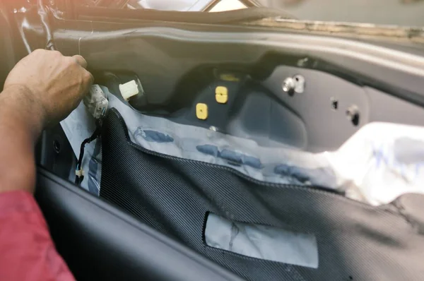 Otomobil tamirhanesinde arabanın motorunu tamir ediyorum. Üniformalı tamirciler otomobil servisinde çalışırken araba tamir ediyorlar