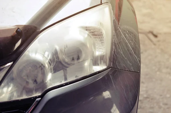 Benzin istasyonunda güç tamponu makinesiyle arabada büyük bir far temizliği, önce ve sonra güç tampon makinesi kullanarak arabanın farlarını temizleyen bir tamirci ile araba konsepti. 