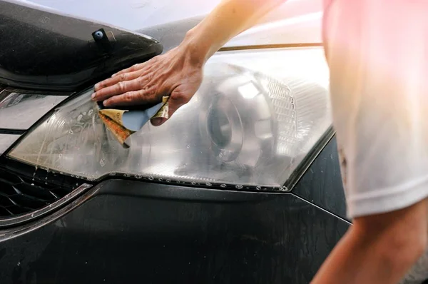 Benzin istasyonunda güç tamponu makinesiyle arabada büyük bir far temizliği, önce ve sonra güç tampon makinesi kullanarak arabanın farlarını temizleyen bir tamirci ile araba konsepti. 