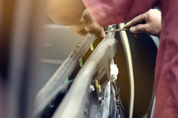 Otomobil tamirhanesinde arabanın motorunu tamir ediyorum. Üniformalı tamirciler otomobil servisinde çalışırken araba tamir ediyorlar