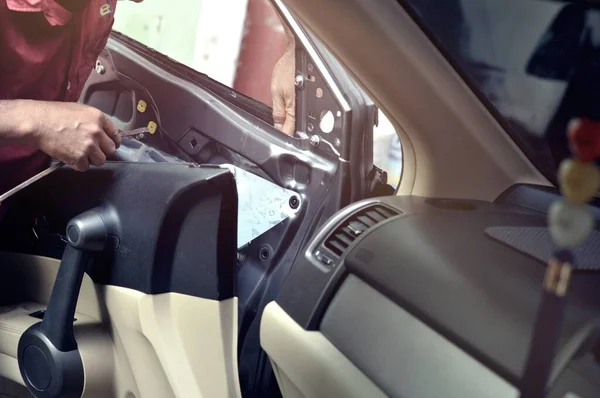 Otomobil tamirhanesinde arabanın motorunu tamir ediyorum. Üniformalı tamirciler otomobil servisinde çalışırken araba tamir ediyorlar