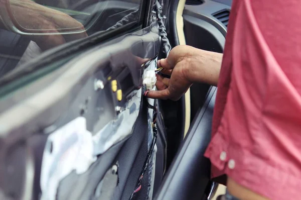 Otomobil tamirhanesinde arabanın motorunu tamir ediyorum. Üniformalı tamirciler otomobil servisinde çalışırken araba tamir ediyorlar