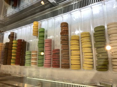 Sokak pazarının arka planında renkli Fransız kurabiyeleri, yakın plan. Farklı renkte badem kurabiyeleri. Lezzetli bir renk makaronu, fırın kavramı..