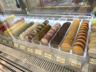 Sokak pazarının arka planında renkli Fransız kurabiyeleri, yakın plan. Farklı renkte badem kurabiyeleri. Lezzetli bir renk makaronu, fırın kavramı..