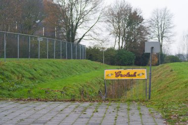 OLDENZAAL, NETHERLANDS - 6 Aralık 2020: Grolsch bira kalkanı olan bir spor parkındaki boş bisiklet parkı. 2016 'dan beri Grolsch Japon Asahi' ye ait.