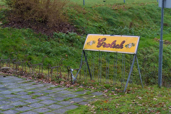 OLDENZAAL, NETHERLANDS - 6 Aralık 2020: Grolsch bira kalkanı olan bir spor parkındaki boş bisiklet parkı. 2016 'dan beri Grolsch Japon Asahi' ye ait.