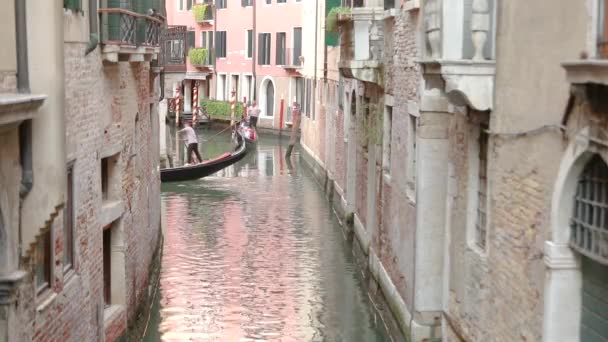 Gôndola com turistas em um belo canal estreito em Veneza. Belo canal de Veneza. Gondolier conduz turistas Veneza, Itália. Lugar romântico Veneza — Vídeo de Stock