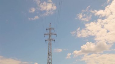 Elektrik taşıma hattı. Yüksek voltajlı kule. Elektrik direklerinin arka planında güzel bulutlar var. Elektrik taşıma hattı. Yüksek voltajlı kule