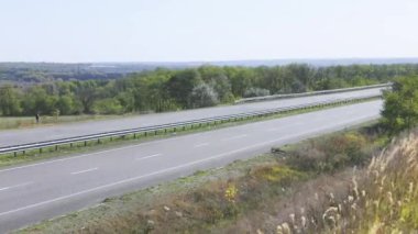 Kamyon otobanda tarlaların ve ağaçların etrafından geçiyor. Kamyon otobanda gidiyor..