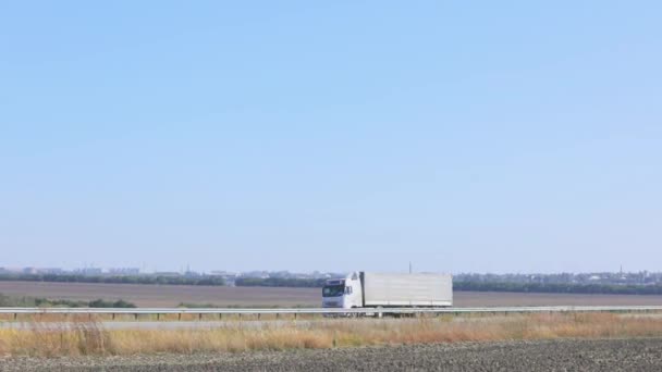 Un camion conduit sur une route en dehors de la ville, un camion cargo moderne conduit sur une autoroute — Video