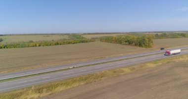 Kamyon uzun, düz bir yol boyunca gider. Kamyon yol boyunca gidiyor, doğa etrafta. Vagon, İHA ateşi altında yol boyunca gidiyor.