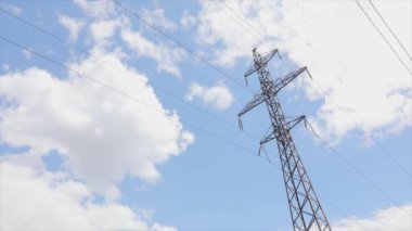 Elektrik taşıma hattı. Yüksek voltajlı kule. Elektrik direklerinin arka planında güzel bulutlar var. Elektrik taşıma hattı. Yüksek voltajlı kule